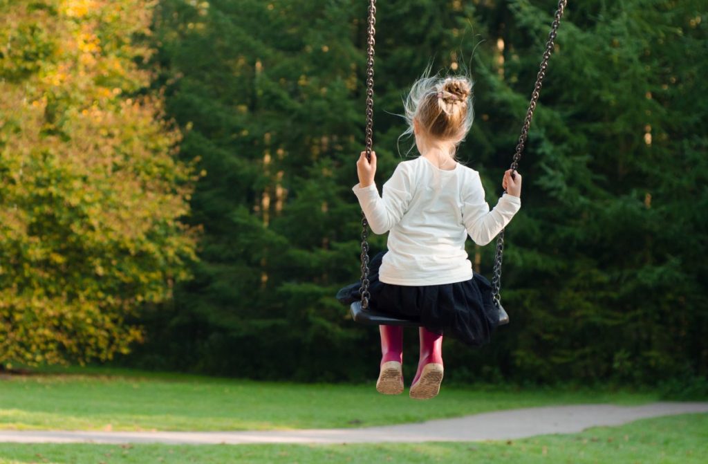 Young girl swinging on a playset